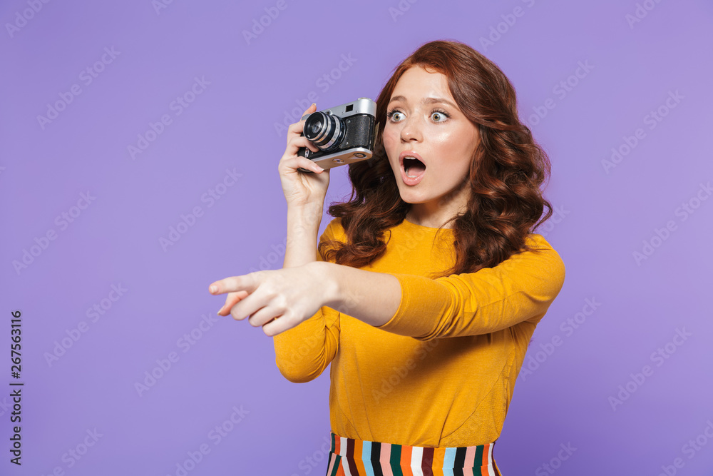 Photo of joyous redhead woman wearing yellow clothes holding retro vintage camera and taking picture Photo of joyous redhead woman wearing yellow clothes holding retro vintage camera and taking picture