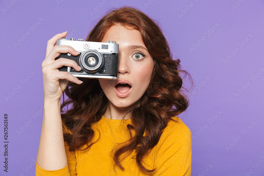 Photo of positive redhead woman wearing yellow clothes holding retro vintage camera and taking picture Photo of positive redhead woman wearing yellow clothes holding retro vintage camera and taking picture