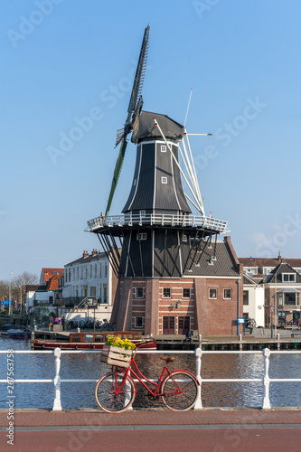 Haarlem, Netherlands – April 14, 2019: View of Harlem Cityscape With De Adriaan Windmill on Spaarne River On Background At Noon in Haarlem, The Netherlands photo