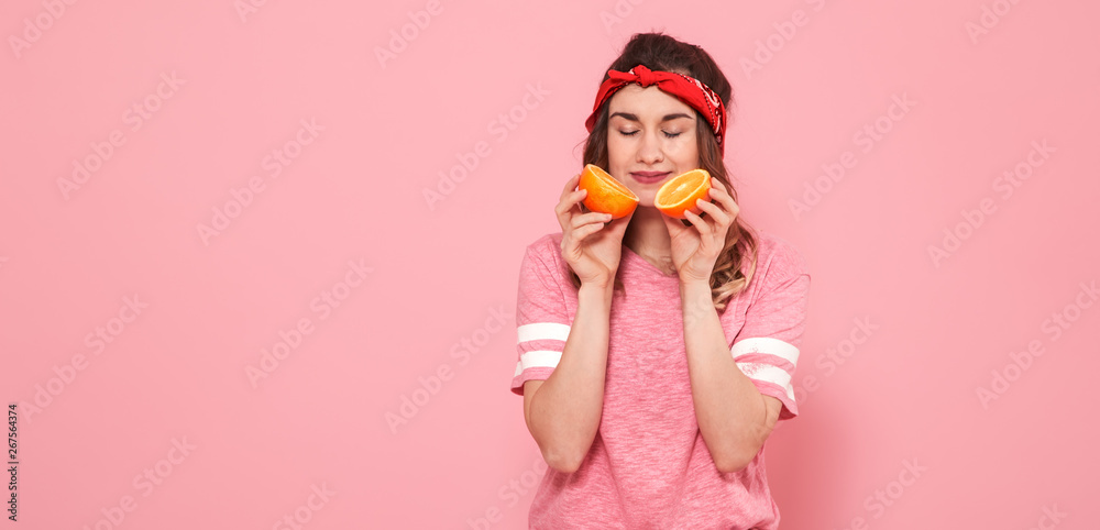 Portrait of a girl with oranges in hand, on a pink background Portrait of a girl with oranges in hand, on a pink background