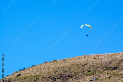 An adventurer glides through the sky over the Yorkshire Moorlands on a clear sunny day photo