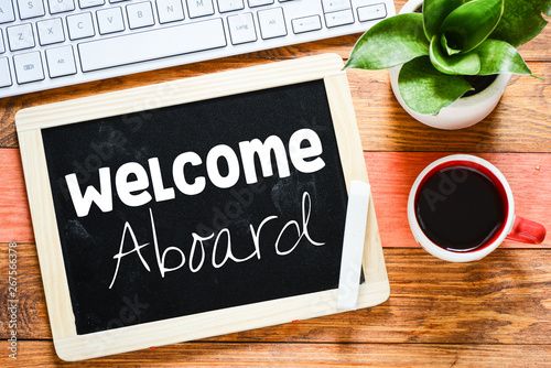 Text Welcome aboard on the blackboard on the desk 