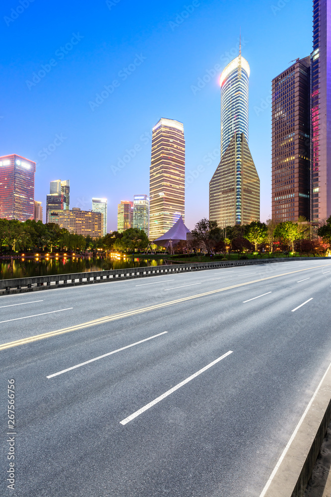 Shanghai modern commercial office buildings and empty asphalt highway at night