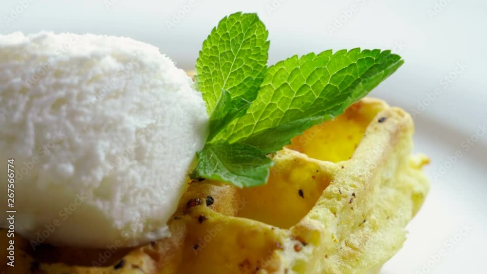 Sweet breakfast. Close-up shot of viennese waffles with ice cream and mint on a white plate. 4K Sweet breakfast. Close-up shot of viennese waffles with ice cream and mint on a white plate. 4K