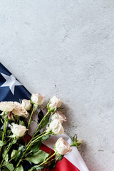 White roses over the USA flag flat lay top view. Independence Day