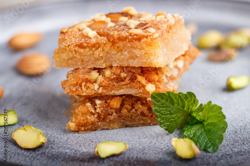 traditional arabic sweets in gray ceramic plate on a gray concrete background. close up. photo