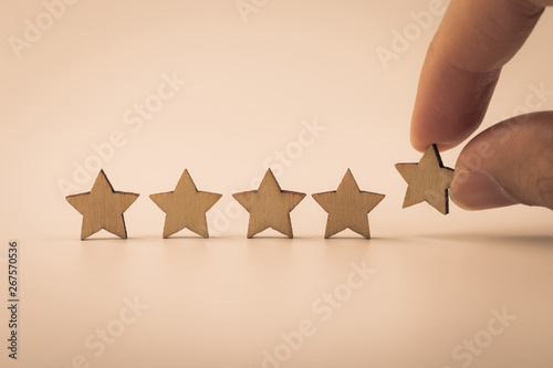 Hand putting wooden five star shape on table