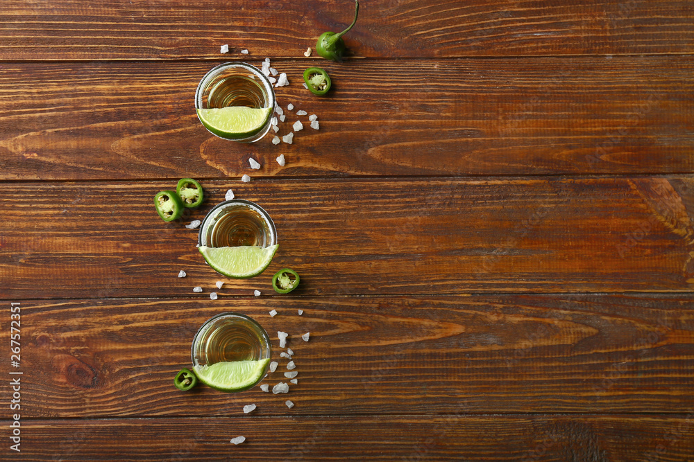 Shots of tequila on wooden table Shots of tequila on wooden table