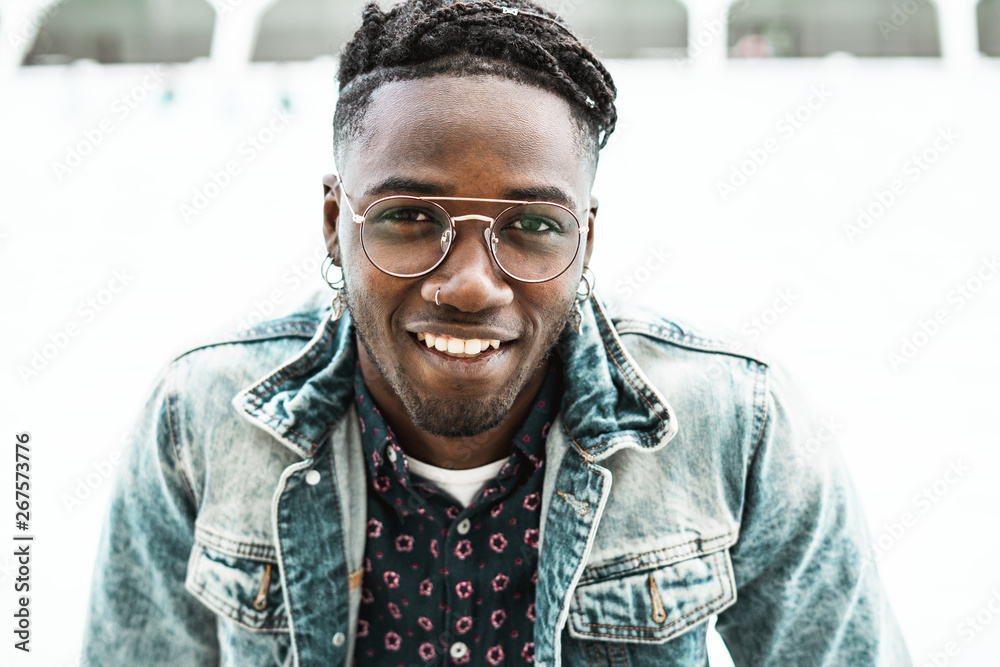 Portrait of handsome African American man smiling in the street with modern glasses Portrait of handsome African American man smiling in the street with modern glasses