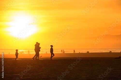 Silhouette people enjoy sunset beach at Santa Monica California, USA