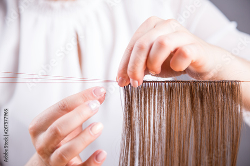 Dłonie młodej kobiety robiącej perukę