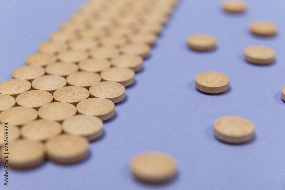 Many brown pills on a purple background Many brown pills on a purple background