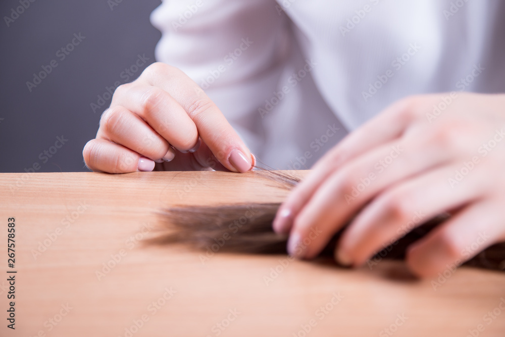 Obraz premium Dłonie młodej kobiety robiącej perukę