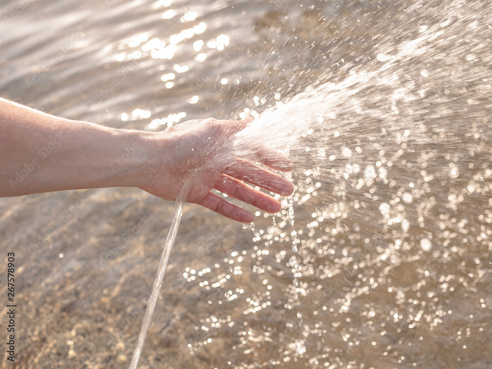 Water from the fountain on the female hand