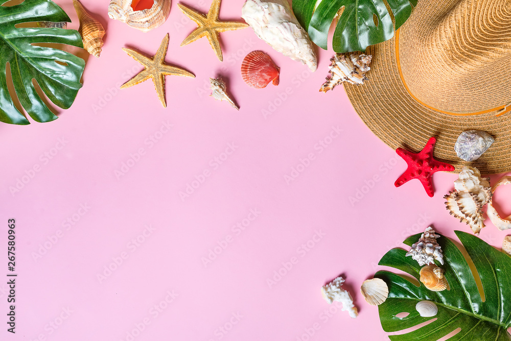 Vacation travel equipment Straw hat, palm leaves and marine objects, shells, starfish On a pink background