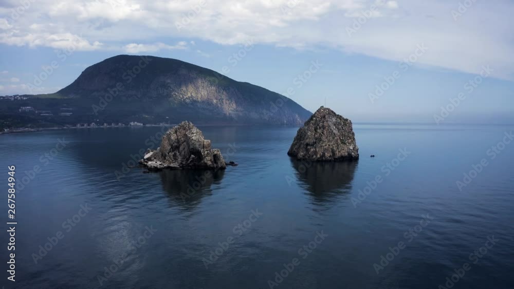 Drone slowly circling around two rocks in the sea in front of the Crimea. Drone slowly circling around two rocks in the sea in front of the Crimea.