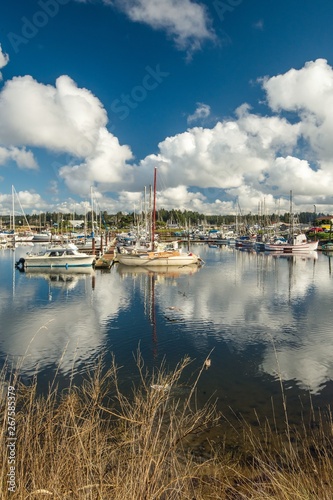 Clouds reflecting in the boat harbor on a sunny summer day photo