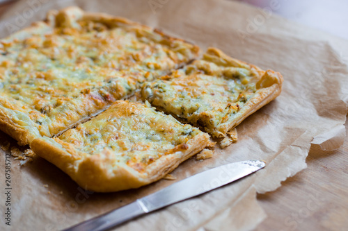 Deliciously simple cheese tart with green peas and eggs on parchment paper. Summer tart. Top view. Copy space