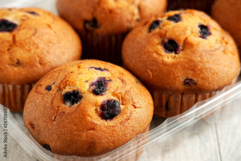 Muffins in the package. Cupcakes with currant berries or blueberries in a package close-up. Muffins for breakfast. Baking with berries.