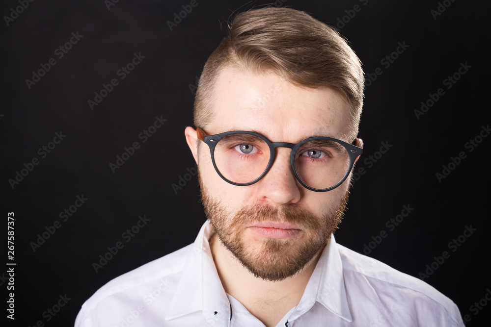 Portrait of bearded handsome man looking at camera isolated over black background Portrait of bearded handsome man looking at camera isolated over black background