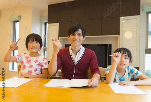 家庭教師　姉妹に勉強を教える先生　イメージ photo