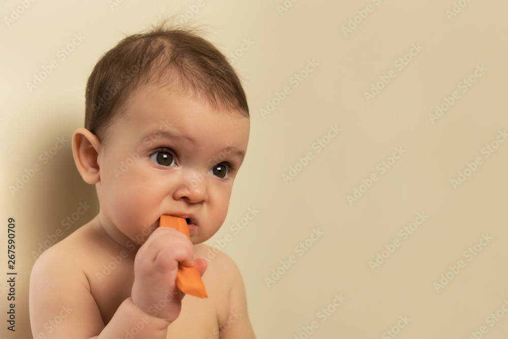 The baby in the diaper is sitting on the kitchen table. A child plays and has fun with fresh organic vegetables and fruits. The baby in the diaper is sitting on the kitchen table. A child plays and has fun with fresh organic vegetables and fruits.