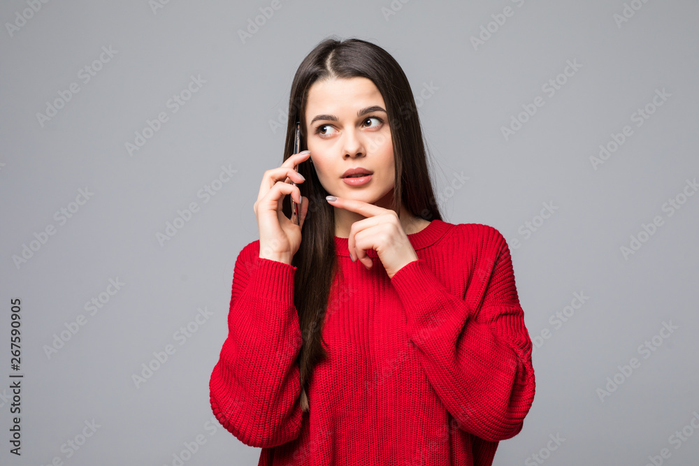 Young woman with red sweater keeping a conversation with the mobile phone on isolated white background Young woman with red sweater keeping a conversation with the mobile phone on isolated white background