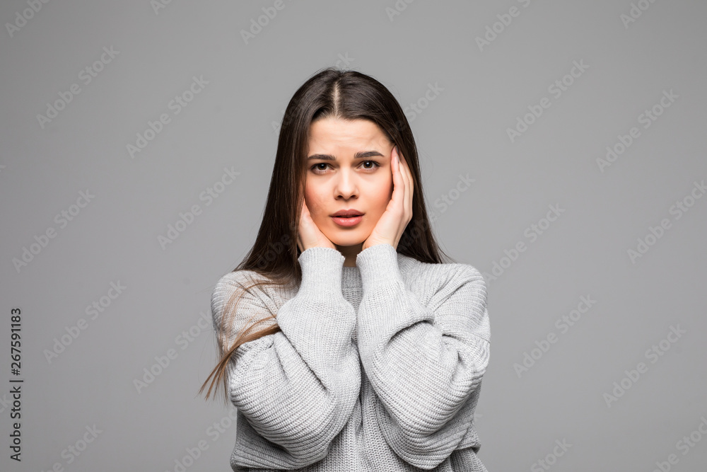 Beautiful young woman with hand on head for pain in head because stress .wearing winter sweater over isolated background Beautiful young woman with hand on head for pain in head because stress .wearing winter sweater over isolated background