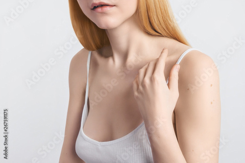 Skin protection Cropped image Young blonde woman's hand is touching her smooth skin on the shoulder Close-up photo