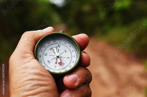 compass in hand on blue sky background