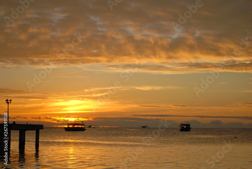 Colourful sunset on th eIndian ocean island wih clouds ocean and boats