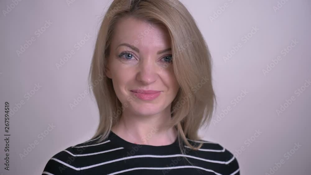 Closeup portrait of adult attractive blonde caucasian female turning to camera and smiling with background isolated on white Closeup portrait of adult attractive blonde caucasian female turning to camera and smiling with background isolated on white