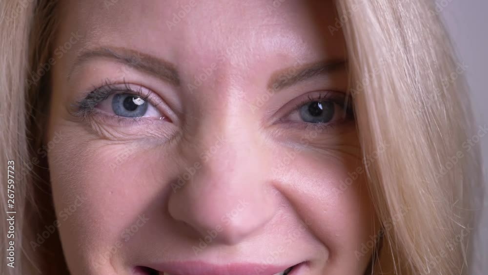 Closeup portrait of adult attractive caucasian female face with eyes looking at camera with happy facial expression with background isolated on white Closeup portrait of adult attractive caucasian female face with eyes looking at camera with happy facial expression with background isolated on white
