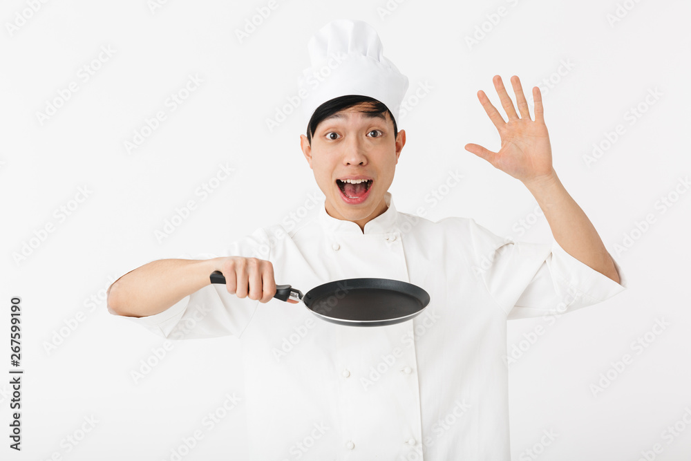 Excited asian chef wearing uniform standing Excited asian chef wearing uniform standing