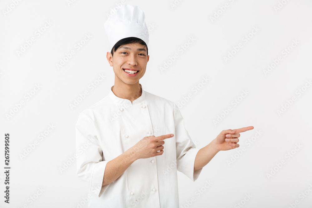 Excited asian chef wearing uniform standing Excited asian chef wearing uniform standing