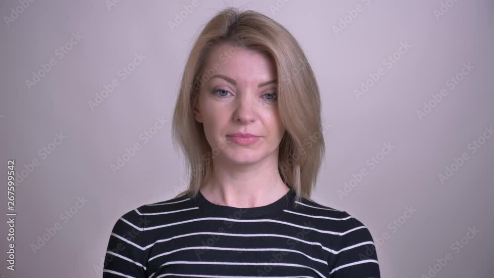 Closeup portrait of adult attractive blonde caucasian female nodding saying yes looking at camera with background isolated on white Closeup portrait of adult attractive blonde caucasian female nodding saying yes looking at camera with background isolated on white