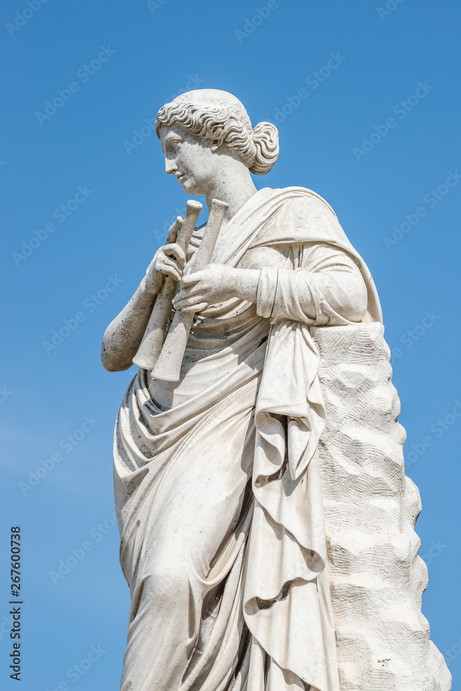 Ancient statue of a sensual renaissance era woman with musical instruments as pipes, in Potsdam, Germany