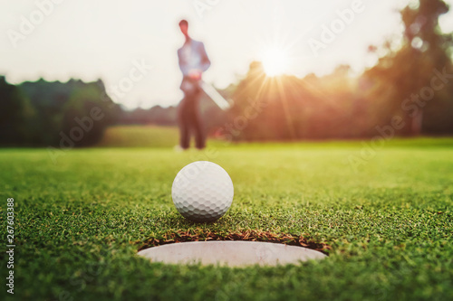 golf player putting golf ball into hole photo