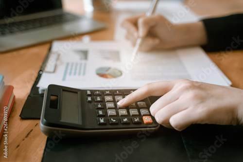 Businesswoman hand pressing on calculator for calculating cost estimating.