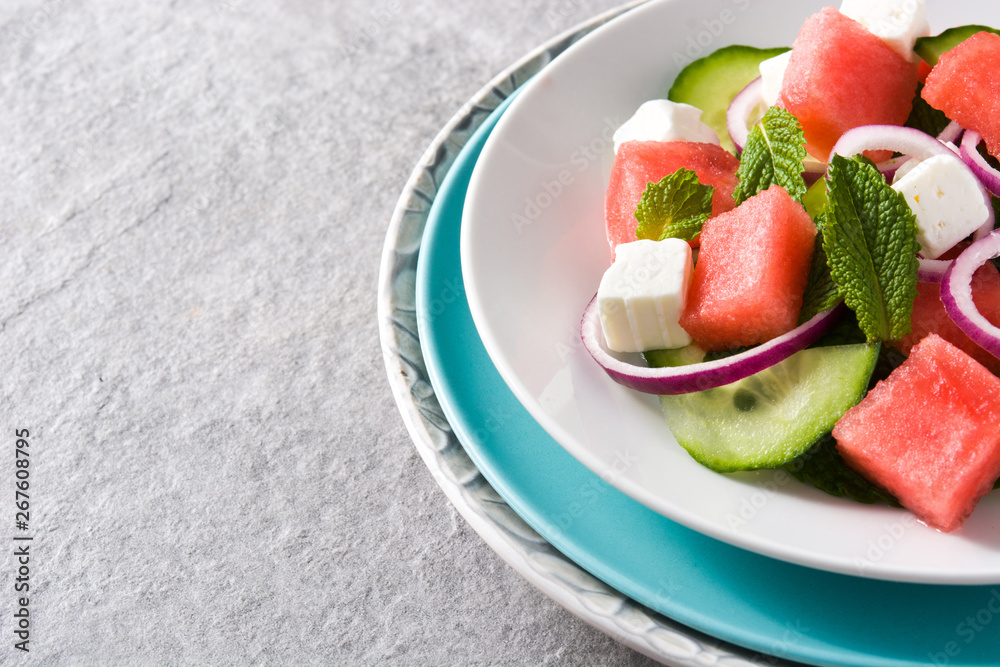 watermelon salad with feta cheese,mint,onion and cucumber on gray background. Copyspace watermelon salad with feta cheese,mint,onion and cucumber on gray background. Copyspace