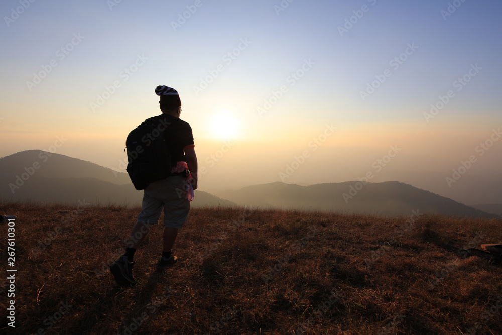 tourism stand on top of mountain seeing sunset