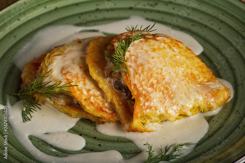 Traditional Belarusian food - potato pancakes with dill and sour cream. Closeup
