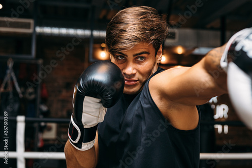 Close up of a male sportsman doing shadow boxing inside a boxing ring © Artem Varnitsin