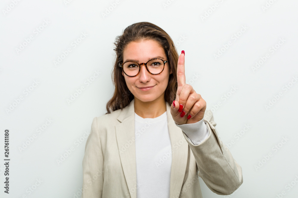 Young european business woman showing number one with finger. Young european business woman showing number one with finger.
