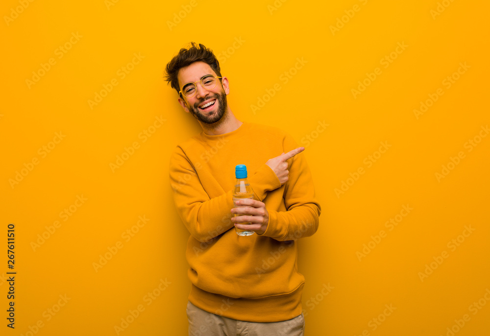 Young man smiling and pointing to the side Young man smiling and pointing to the side