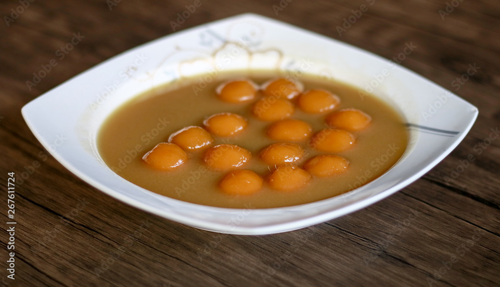 Biji salak on wood background. Biji salak is sweet potato dumplings with coconut sauce. Popular dessert in Indonesia or to break the fast. Biji salak on wood background. Biji salak is sweet potato dumplings with coconut sauce. Popular dessert in Indonesia or to break the fast.