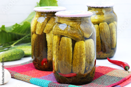 Marinated cucumbers in jars on a white background