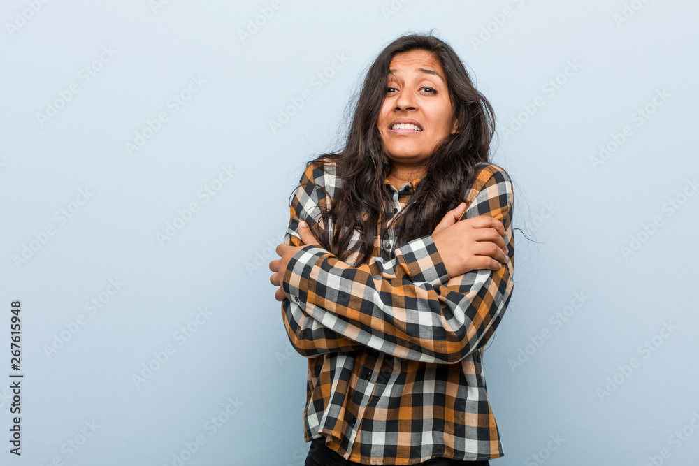 Young cool indian woman going cold due to low temperature or a sickness.