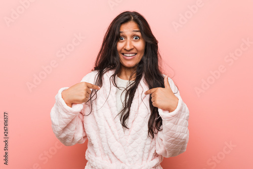 Young indian woman wearing pajama surprised pointing at himself  smiling broadly.