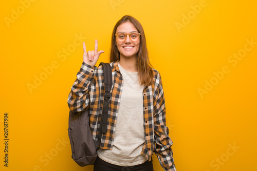 Young student woman doing a rock gesture
